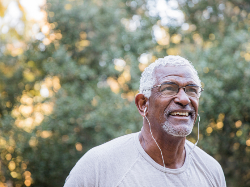 older Black man exercising outdoors with headphones