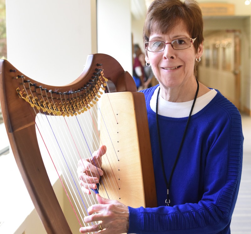 Adult volunteer playing harp