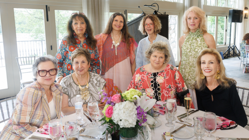 group of women around table posing for a photo