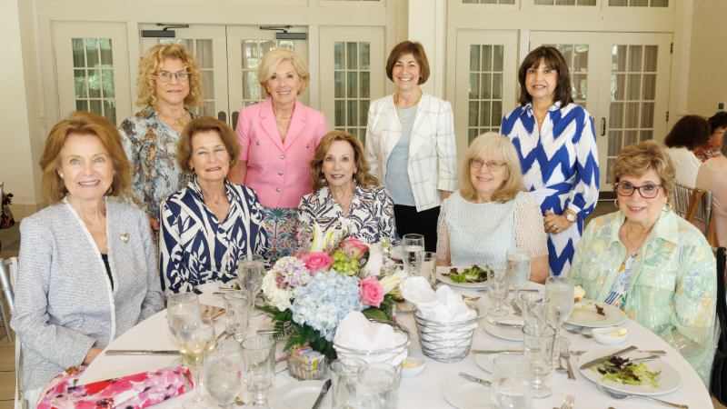 group of women around table posing for a photo
