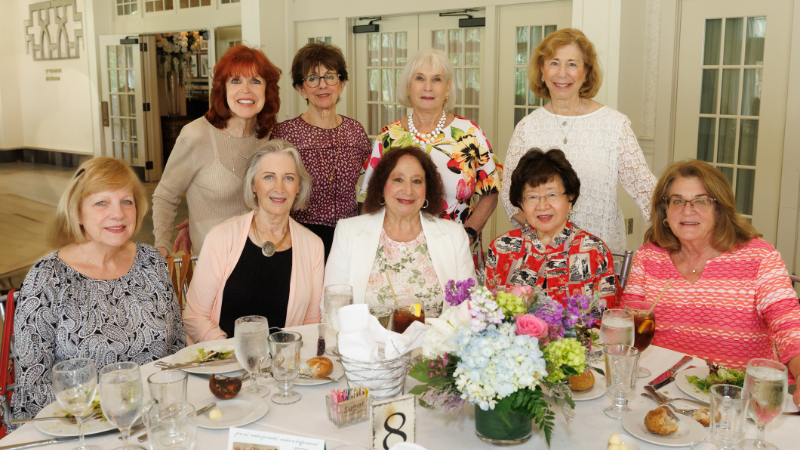 group of women around table posing for a photo
