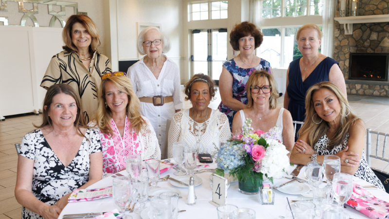 group of women around table posing for a photo