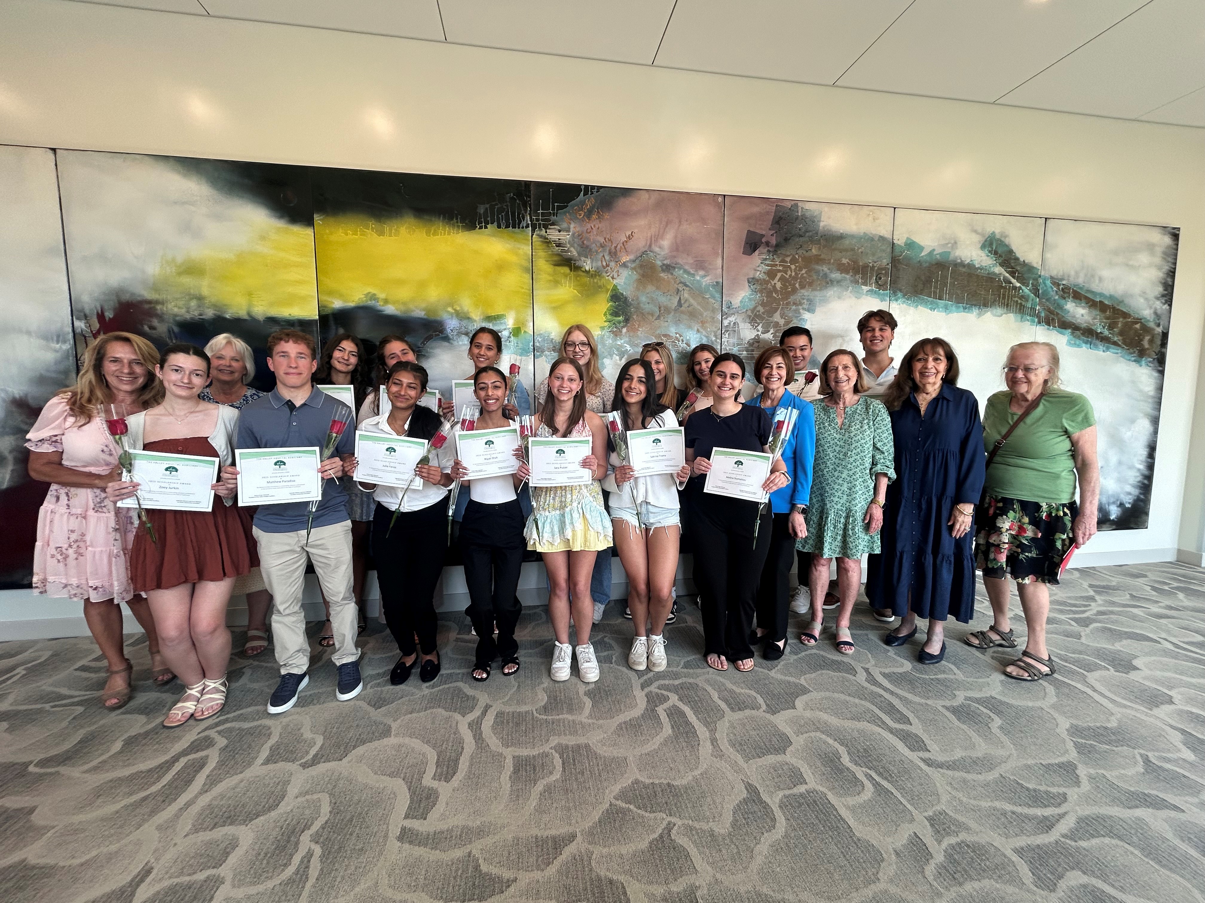 group of scholarship winners standing in front of a painting