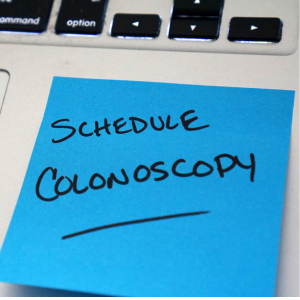 post it note on laptop that says "schedule colonoscopy"