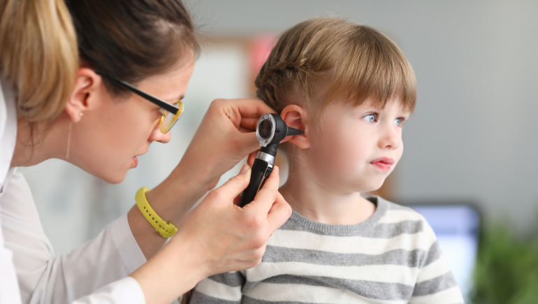 girl getting her ears checked by a doctor