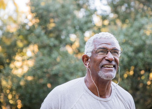 older Black man exercising outdoors with headphones