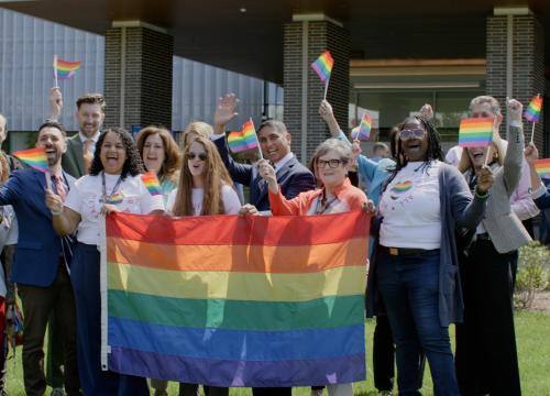 group of employees celebrating the pride flag raising ceremony