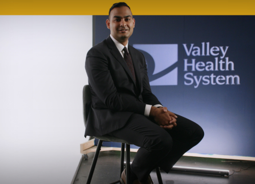 Dr. Malick sitting on chair being interviewed