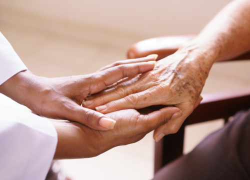 senior woman holding hands with health care provider