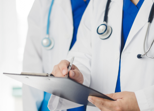 doctor writing on clipboard