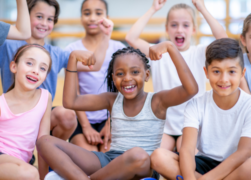 children smiling and showing their muscles
