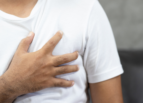 man clutching chest with heart palpitations