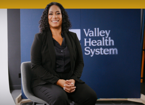 Xelenia Depena, MD, sitting being interviewed