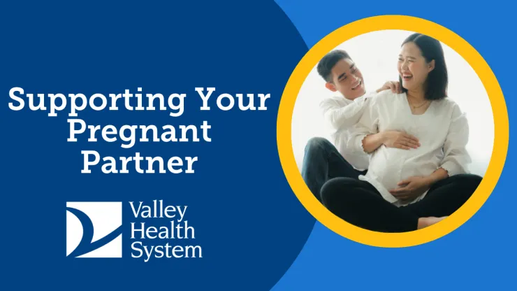 man rubbing his pregnant partner's shoulders