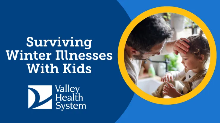 father taking temperature of his toddler daughter by feeling her forehead