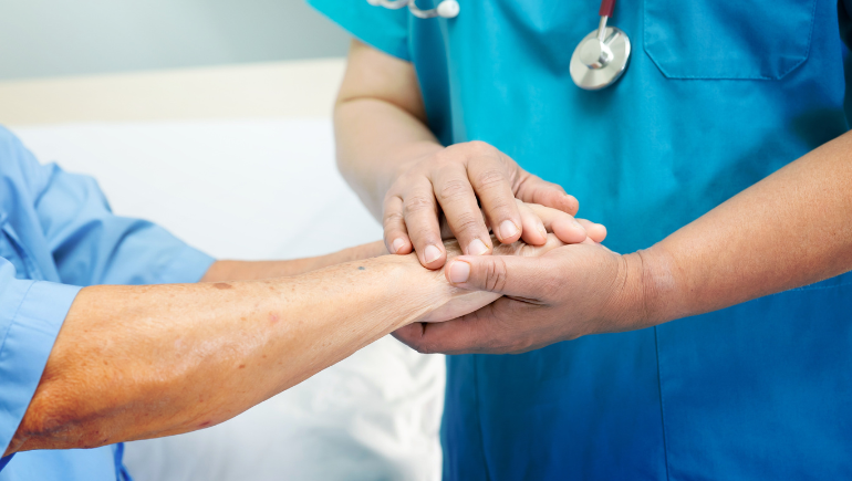 patient and caregiver holding hands