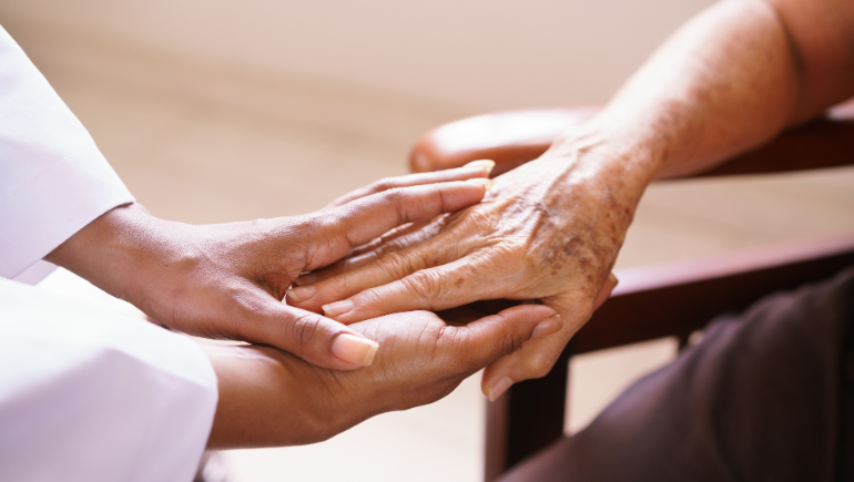 patient and caregiver holding hands