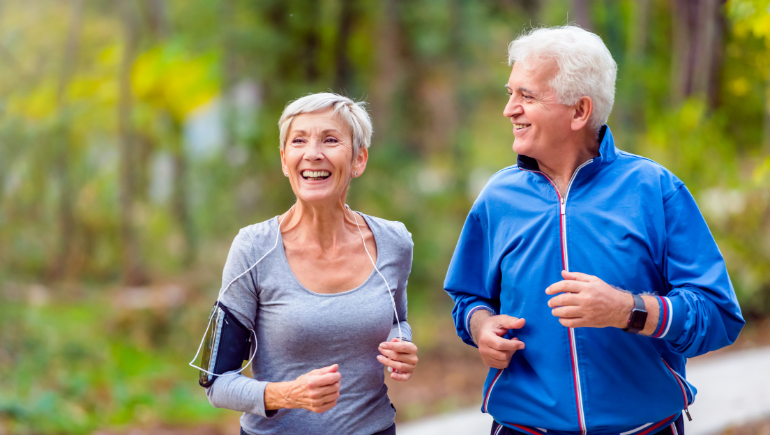 senior man and woman smiling and jogging together