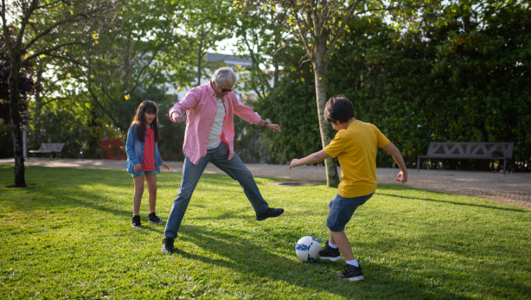 active grandparent playing soccer with grandchildren