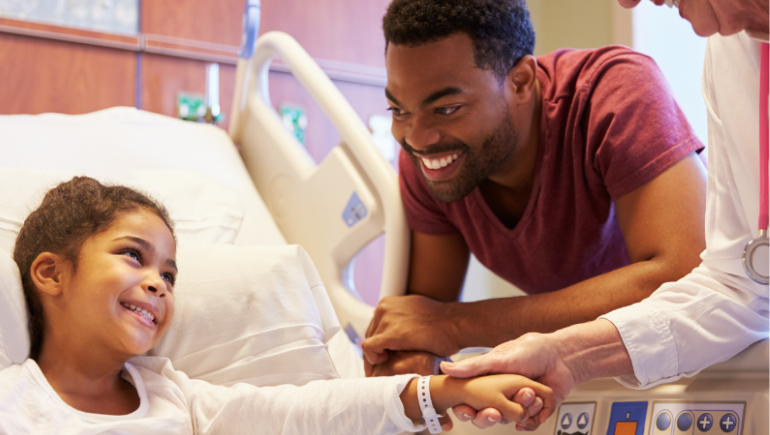pediatric patient smiling with her father