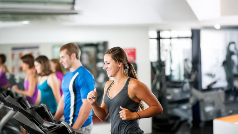 people exercising on treadmills at gym