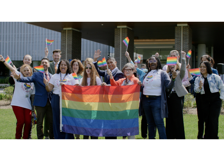 group of employees celebrating pride flag raising ceremony