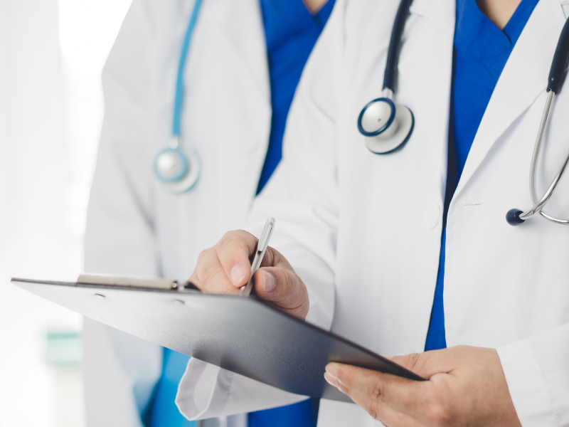 doctor writing on clipboard