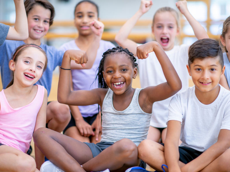 children smiling and showing their muscles
