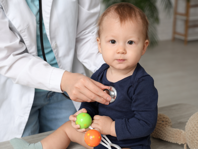 infant boy getting examined by a pediatrician