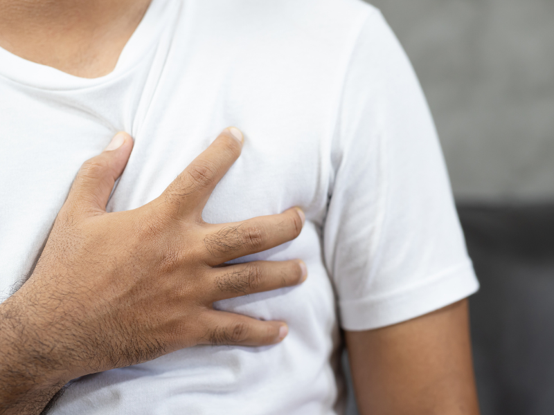 man clutching chest with heart palpitations